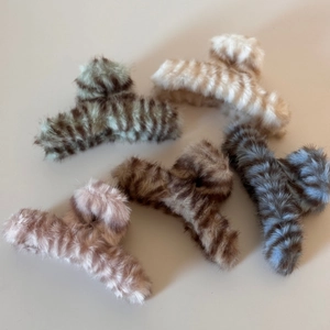 Detailansicht der flauschigen Haarklammern mit Tigermuster in verschiedenen Naturtönen