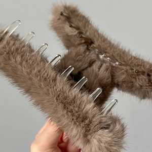 Gros plan d'une grande pince à cheveux en peluche marron café à texture douce