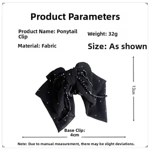 Detail view of a black beaded bow hair claw clip showing 13cm height and 32g weight specifications
