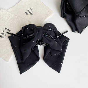 Detail of black chiffon bow hair claw clip with silver glitter and beaded tassel chain