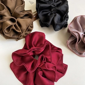 Close-up of four-layer satin hair scrunchies showing smooth texture and sewing detail