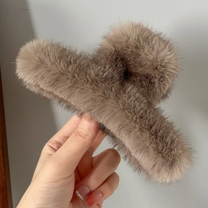 Vue détaillée de la grande pince à cheveux en fausse fourrure marron au toucher doux
