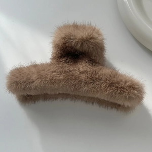 Détail de la pince à cheveux en peluche marron avec texture douce en fausse fourrure
