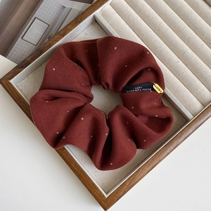 Detail of burgundy polka dot scrunchie with Lucky charm in a wooden jewelry box