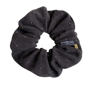Elegant dark grey polka dot fabric scrunchie with Lucky metal charm and brand tag