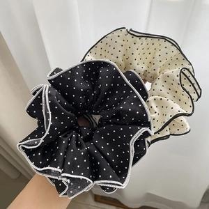 Close-up of black and white polka dot scrunchie set with delicate hemmed edge details