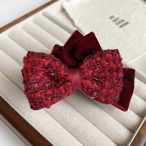 Detailed close-up of dark red tweed and velvet bow hair claw clip with golden silk threads