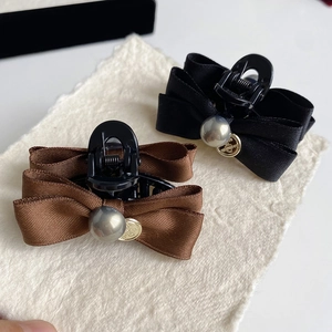 Detail of silk bow hair claw clips with gray pearl and gold engraved metal charm