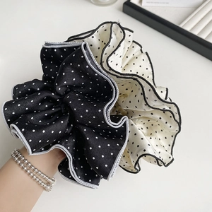 Elegant oversized polka dot scrunchie in black and white satin with ruffled design