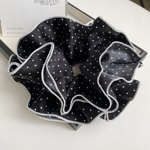 Detail of vintage black and white polka dot scrunchie with elegant piped edge design