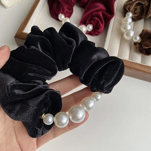 Elegant black velvet scrunchie with large white pearls for a sophisticated hair accessory look
