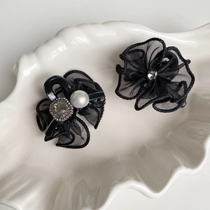 Elegant black mesh flower hair clip set with pearls and rhinestones on a white tray