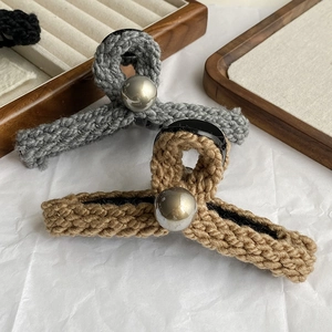 Gros plan sur une pince à cheveux en maille avec texture de laine et perle argentée