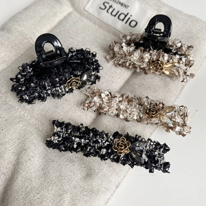 Detailed set of tweed hair clips with golden camellia flowers and rhinestones