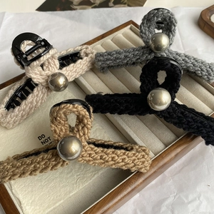 Pinces à cheveux en tricot d'hiver avec perle en beige, gris et noir sur plateau bois