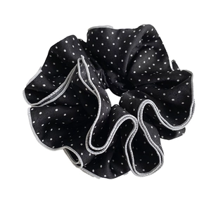 Elegant black and white polka dot scrunchie with grey stitched edges for a retro French look