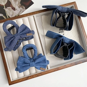 Détails de pinces à cheveux en jean bleu avec nœuds et petite étiquette en cuir