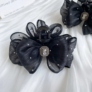Detail of black mesh bow hair claw clip with crystal embellishments and center gem