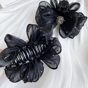 Elegant set of two black mesh bow hair claws with sparkling rhinestones on white silk