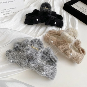 Knitted bow claw clips in black, grey and khaki with pearl details on satin background