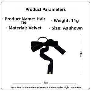 Detail of black velvet bow hair scrunchie with dimensions 14cm x 24cm and gold charm