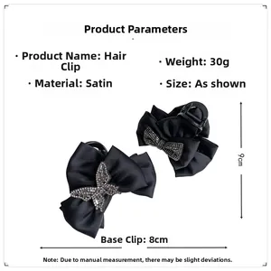Detail of black satin bow hair claws featuring elegant rhinestone butterfly embellishments