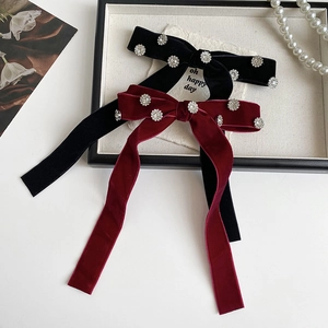 Detail view of elegant velvet bow hair clips with crystal rhinestones in black and burgundy