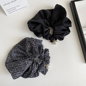 Detail of satin scrunchie set with white polka dots and elegant pearl pendant