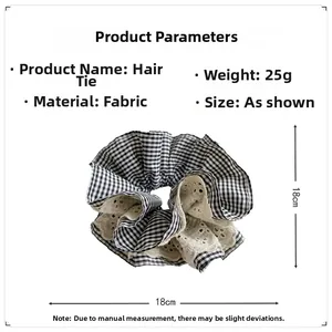 Detailed close-up of a large black and white checkered scrunchie with white lace edges