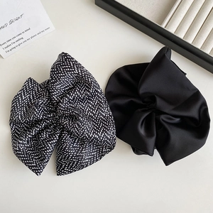 Close-up of black and polka dot satin scrunchies with smooth texture and elegant folds