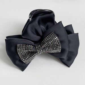 Detail of multi-layer black satin bow hair claw clip with crystal rhinestones