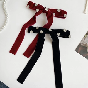 Detail of red and black velvet bow clips with sparkling rhinestone flower embellishments