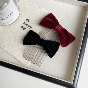 Close-up of velvet bow hair combs in red and black with 10 metal teeth for styling