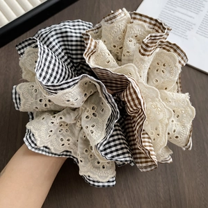 Detailed view of a large multi-layer plaid scrunchie with delicate beige lace embroidery