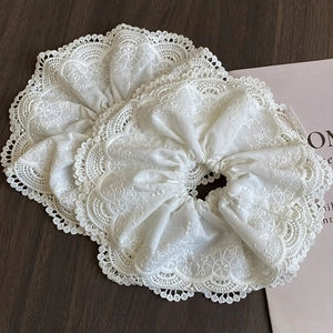 Elegant white lace floral embroidery scrunchies on wooden table, two-piece set