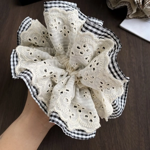 Detail of checkered fabric and beige lace edge on the large ruffled scrunchie