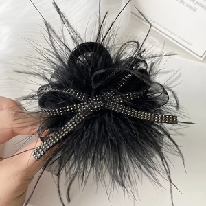 Elegant black feather hair claw with rhinestone bow for wedding or party hairstyles