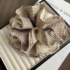 Detail of vintage brown plaid scrunchie with white lace trim in a velvet box