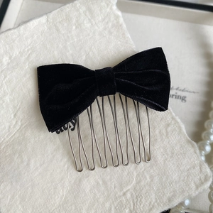 Close-up of black velvet bow hair comb with high-quality fabric and metal teeth for styling