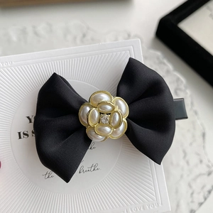 Elegant black bow hair clip with camellia pearl detail and golden accent for women