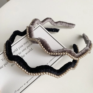 Détail de serre-têtes en velours noir et gris avec perles et design ondulé élégant