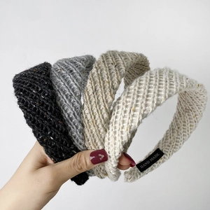 Detail of four-color knitted headbands with handmade labels in black, grey, coffee and beige