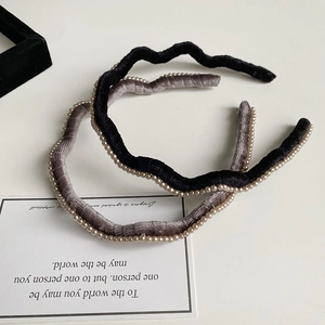 Détail de serre-têtes ondulés en velours avec perles en noir et gris élégants