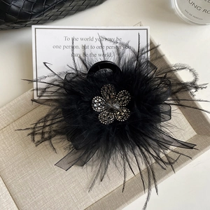 Elegant black feather hair claw clip with rhinestone flower in a luxury gift box