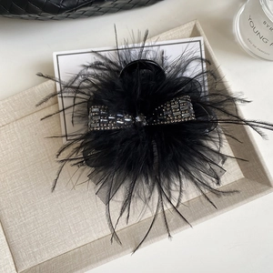 Elegant black feather hair claw clip with rhinestone bow accent for luxury hairstyles