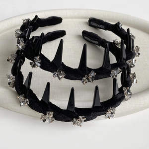 Detail of two punk style velvet headbands with black spikes and crystals in a tray