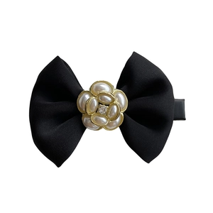 Elegant black satin bow hair clip featuring a pearlescent camellia flower with crystal center