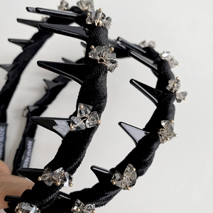 Detail of handmade black velvet headband with punk spikes and gray crystals weave