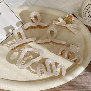 Detailed set of 7 elegant acetate hair clips with pearl white finish and gold-tone metal