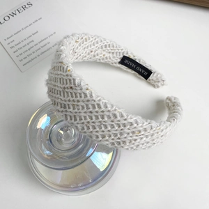 Detail shot of a hand-made cream knitted headband with a textured wool stripe finish
